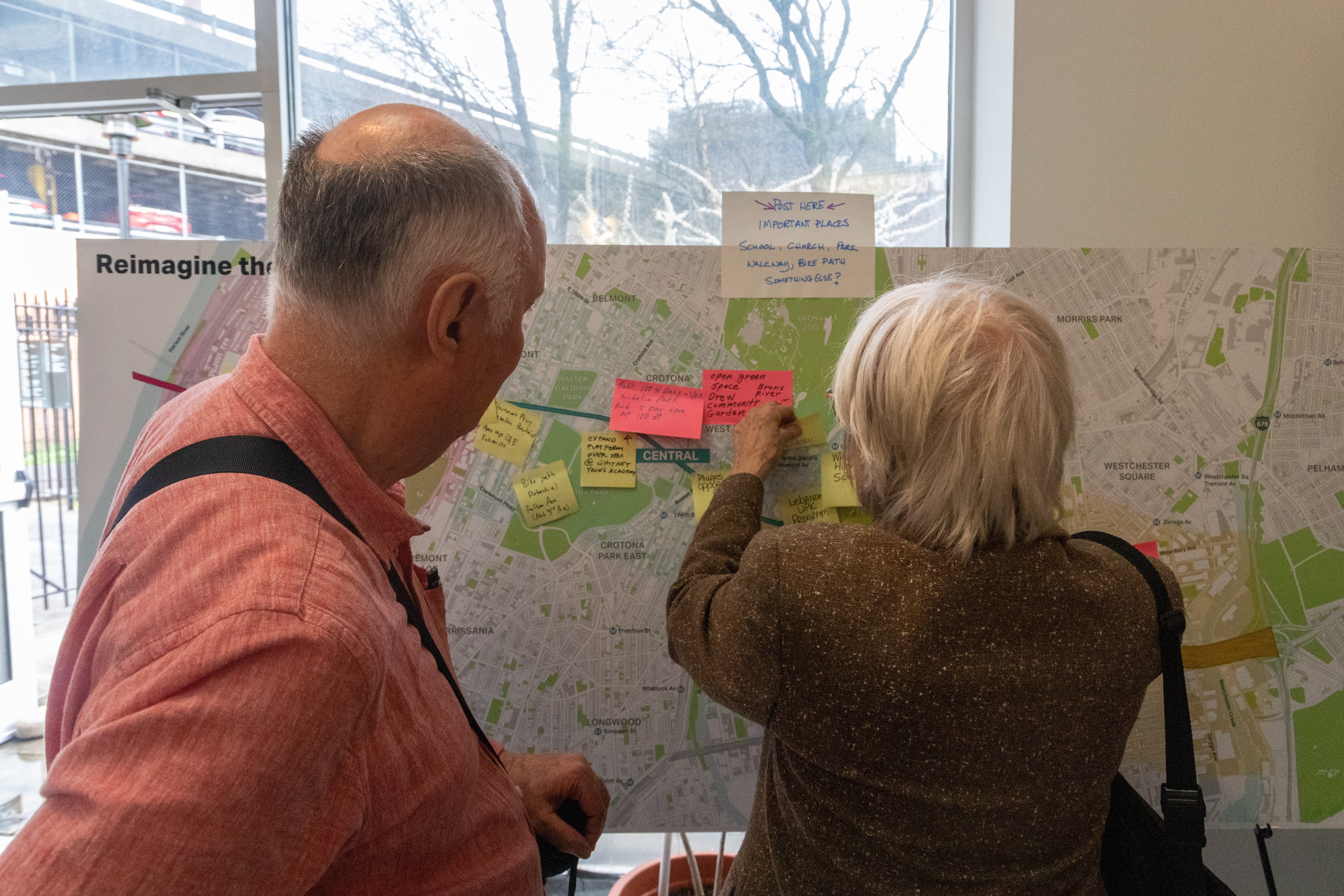 Two people put post it notes onto a large map of the Cross Bronx Expressway during a public open house