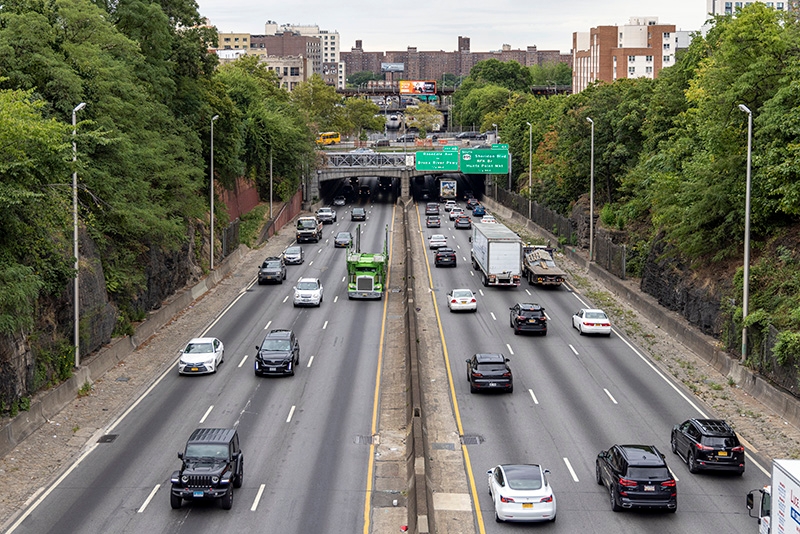 Six lanes of traffic travel on a highway in the Bronx